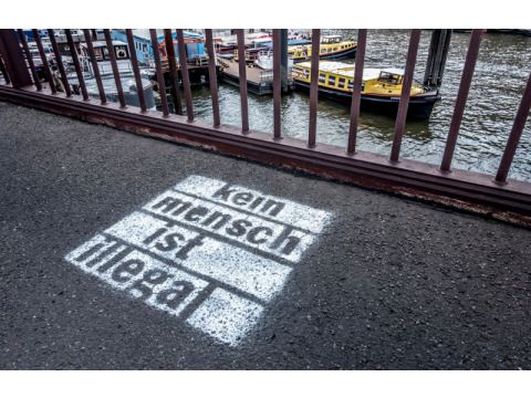 Schriftzug auf den Boden gesprüht kein Mensch ist illegal