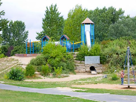 Ein Spielplatz mit einer Rutsche und Klettergerüsten auf dem Kinder spielen
