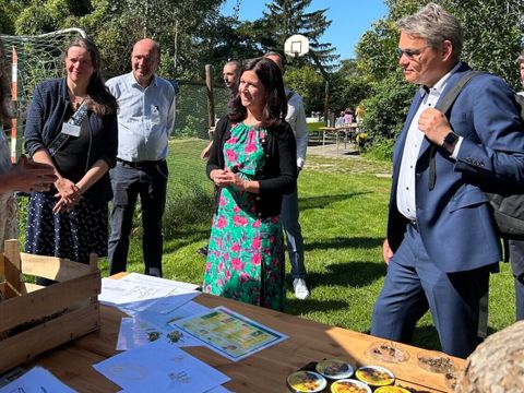 Bildungssenatorin Katharina Günther-Wünsch (mittig) und Bezirksbürgermeister Jörn Oltmann (rechts) an einem Informationsstand zu Bienen und Honig