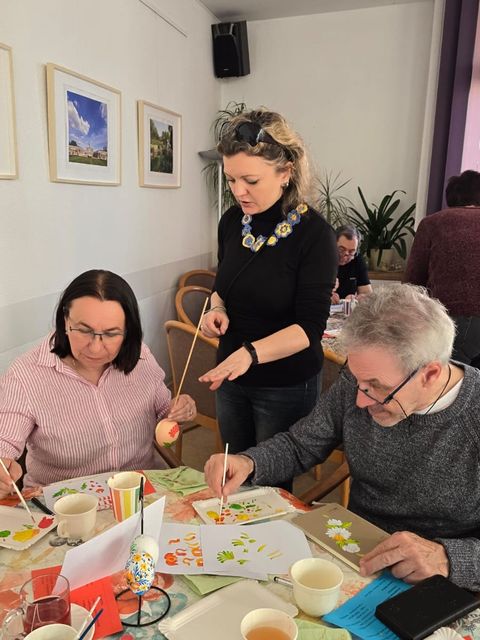 Bürger*innen bemalen Eier unter Anleitung