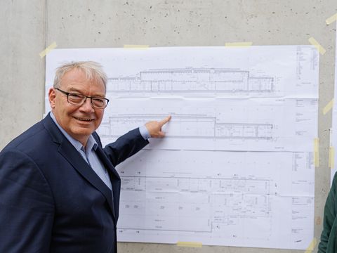 Harald Muschner, Bezirksstadtrat für Bildung, Sport, Kultur und Facility Management verweist auf die Photovoltaik auf dem Dach.