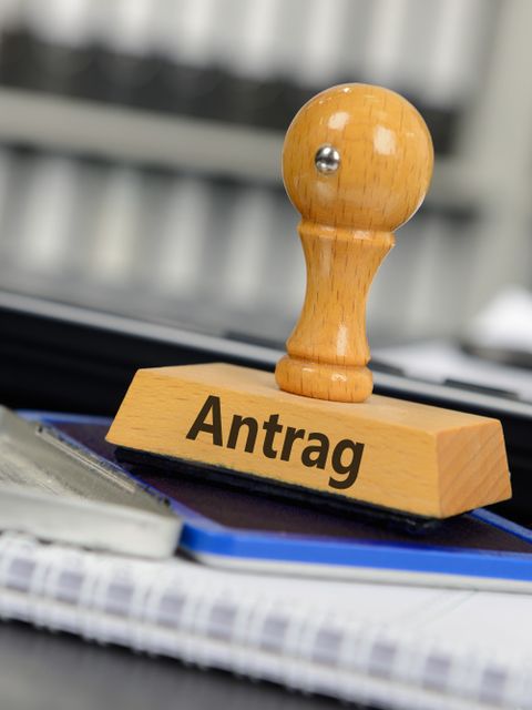 Stempel mit der Aufschrift 'Antrag' steht auf einem Stempelkissen