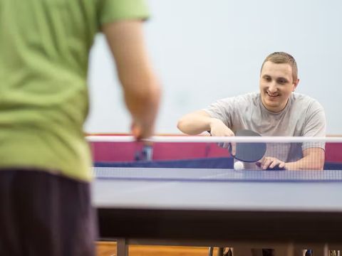 ein Mann im Rollstuhl spielt Tischtennis