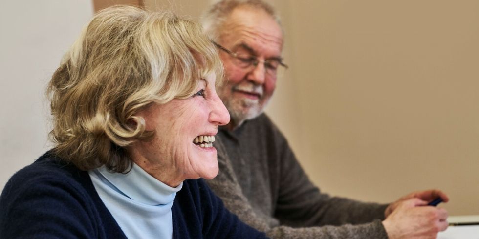 ältere Teilnehmende lächelt herzlich in den Kursraum