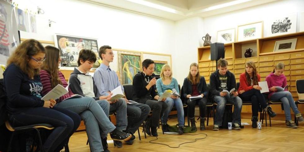 Jugendliche sitzen im Stuhlkreis und hören zu