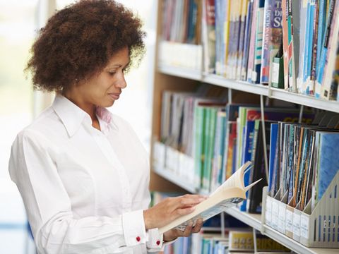 Frau beim Lesen in der Bibliothek