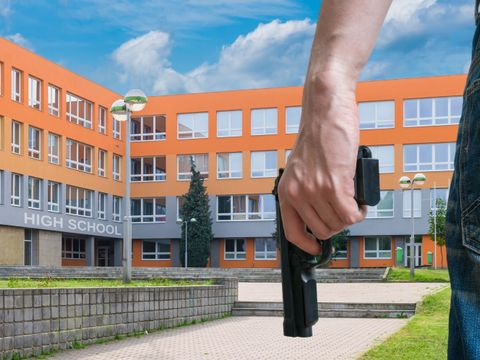 Junge bewaffneten Mann hält Pistole in der Hand an einem öffentlichen Ort
