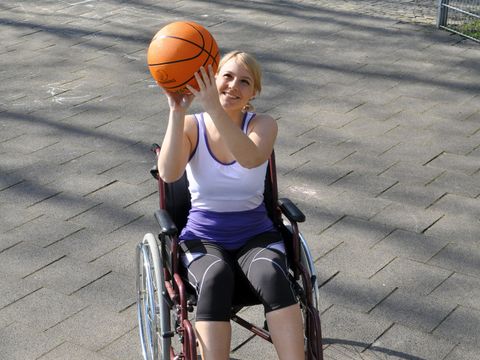 Frau im Rollstuhl spielt Basketball