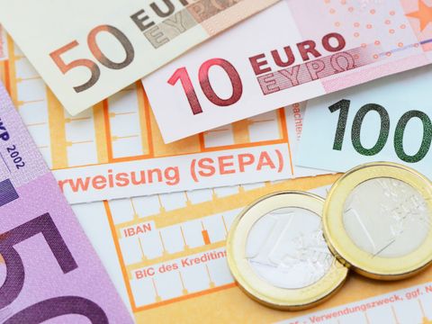 Geldscheine, Münzen und nicht ausgefüllte Überweisungsformulare