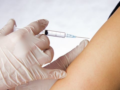 Mediziner verabreicht Spritze an einem Arm