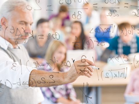 Lehrer schreibt an die Tafel Formeln