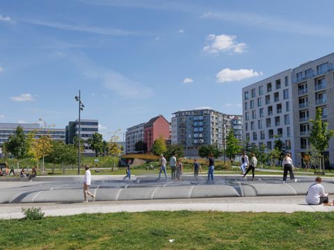 Während manche auf den Sitzkanten Platz nehmen, klettern andere auf den Wasserstein und sind dankbar für die feinen Sprühnebel.