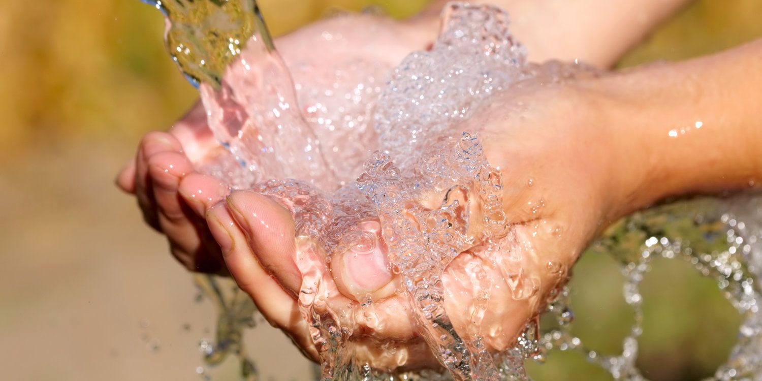 Hände werden unter einem Wasserstrahl gehalten