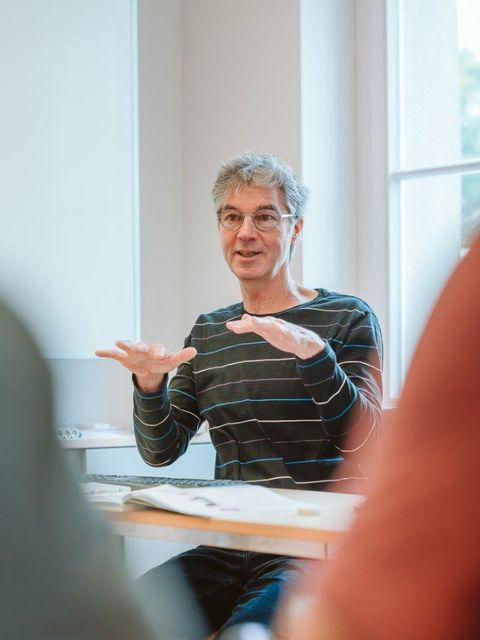 Dr Georg Jansen sitzende im Unterricht - Gestik 3