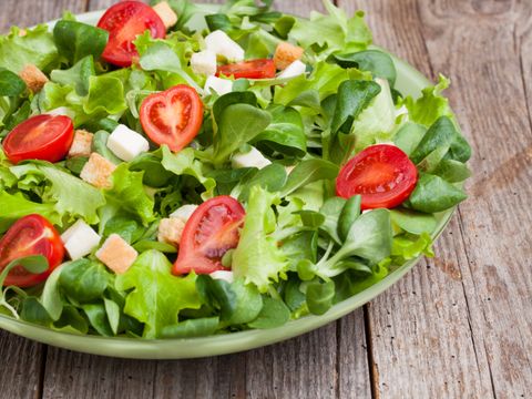 Eine Schüssel mit grünem Salat und Tomaten