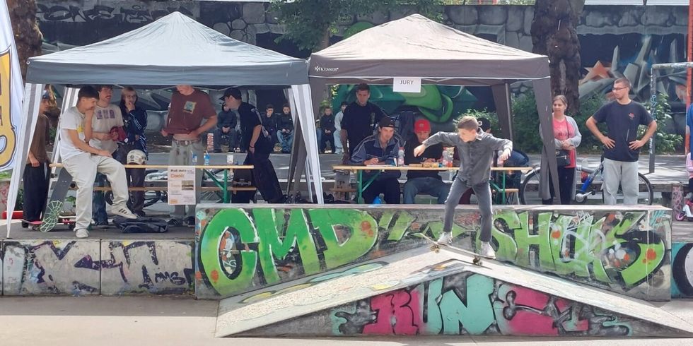 Ein Jugendlicher präsentiert sein Können auf einem Skaterwettbewerb