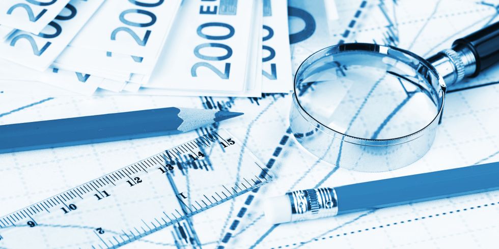 Diagramme, Geldscheine, Lupe und Bleistifte