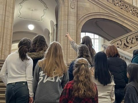 Schülerpraktikanten stehen auf einer Treppe und Blicken nach oben