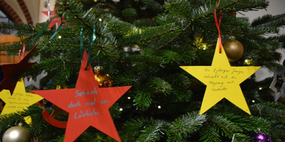 Sterne am Wunschbaum mit der Aufschrift: "Schenk doch mal ein Lächeln"