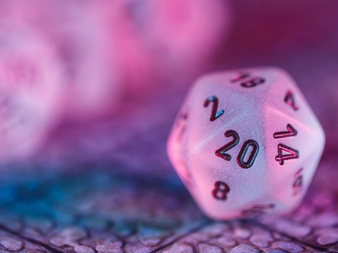 Symbolbild: zwanzigseitiger Würfel in dramatischem pinken Licht
