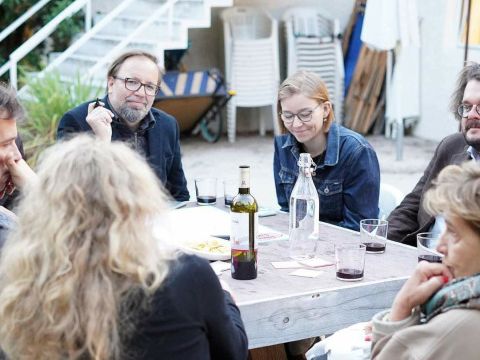 Erwachsene sitzen um einen Tisch herum