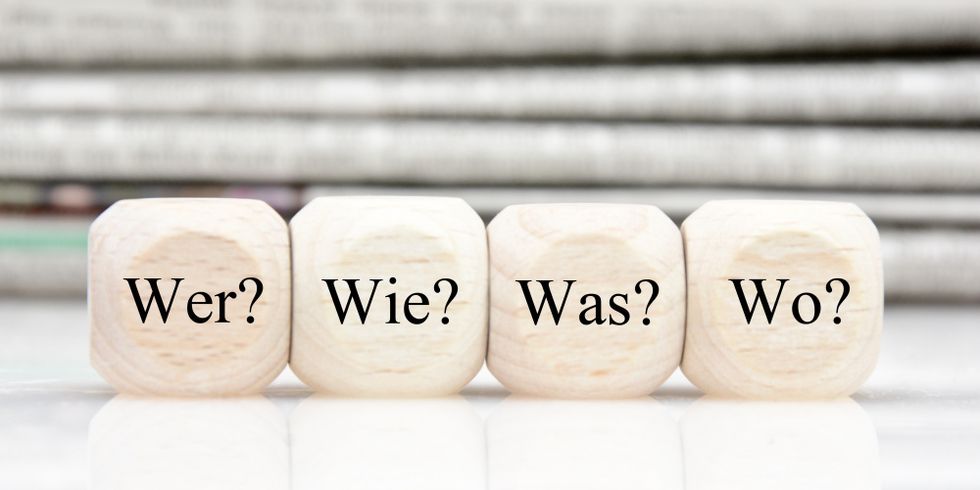 Vier Würfel mit den Fragen Wer? Wie? Was? Wo?