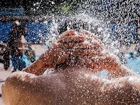 Foto von einem Mann. Er duscht im Freibad.