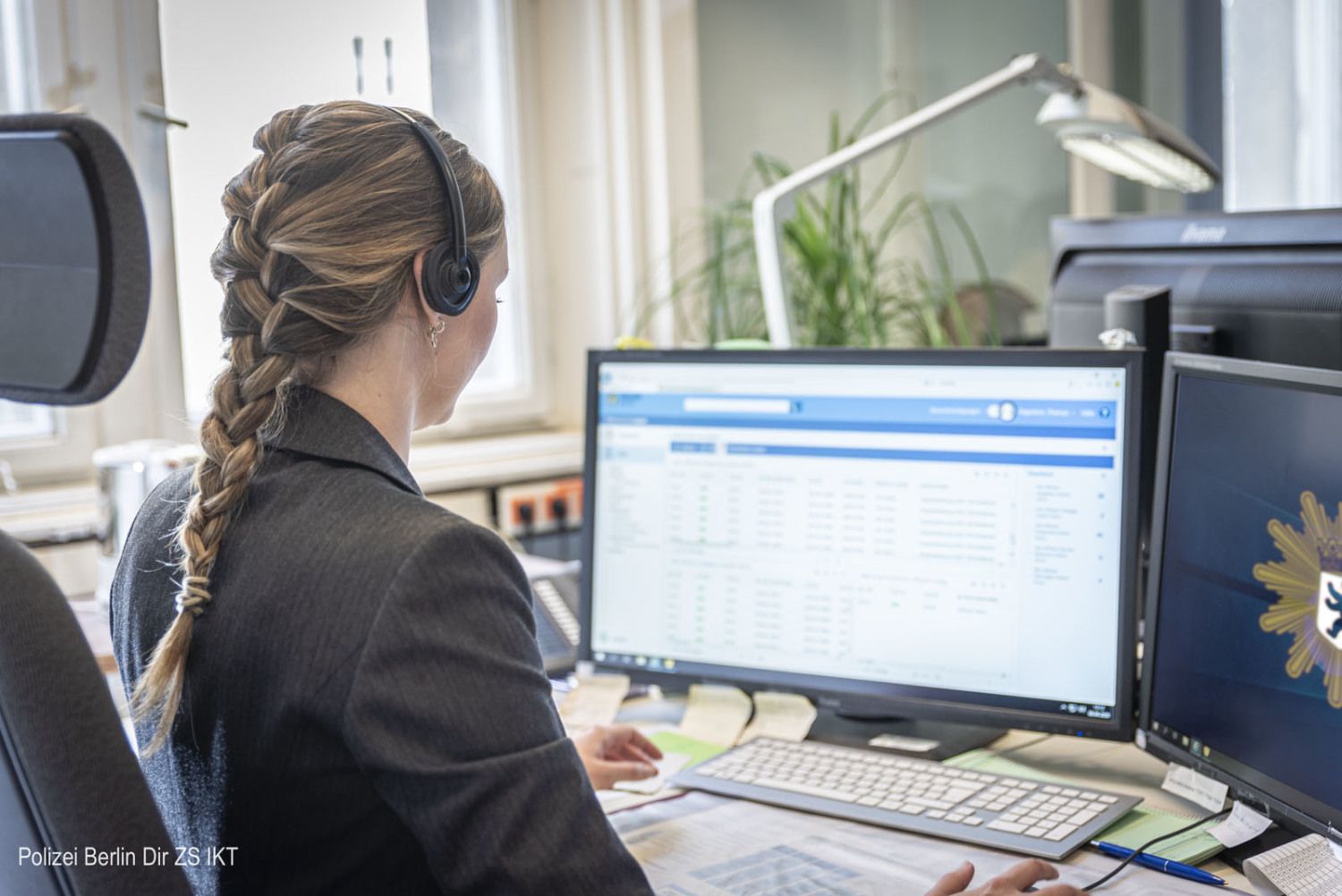 Mitarbeiterin am Arbeitsplatz vor zwei Monitoren