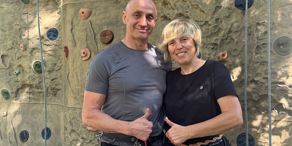 Alexander Danilov mit seiner Frau mit erhobenen Daumen vor dem Kletterfels