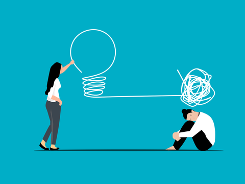 Eine Frau sitzt mit Strichknäuel über dem Kopf, während eine andere Frau auf eine Glühbirne zeigt