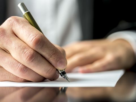 Hand bei Unterschrift Notiz Vertrag