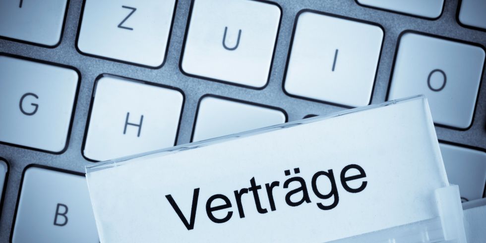 Akte mit dem Reiter "Verträge". Im Hintergrund liegt eine PC-Tastatur.