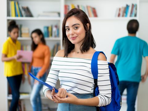 Schülerin vor Bücherregal