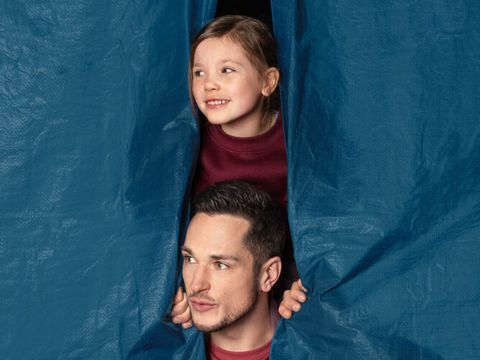 Tag der Städtebauförderung 9. Mai 2026: Ein Mann und ein Kind kucken zwischen einem blauen Vorhang hervor