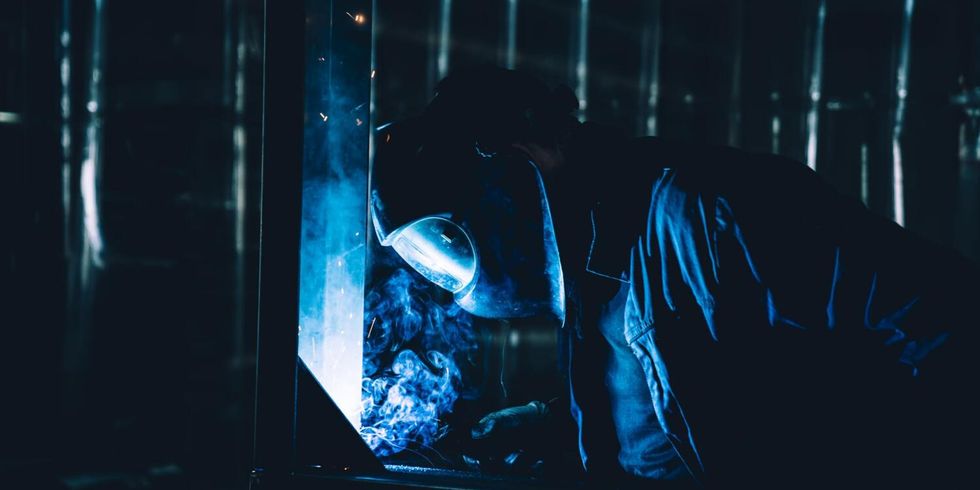 Ein Beschäftigter in Schutzkleidung erledigt Schweißarbeiten.