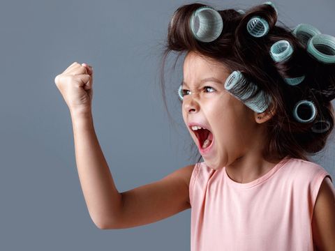 Niedliches kleines Mädchen in rosa Kleid und Lockenwickler