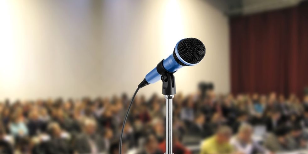 Mikrofon vor einem Hörsaal mit Menschen