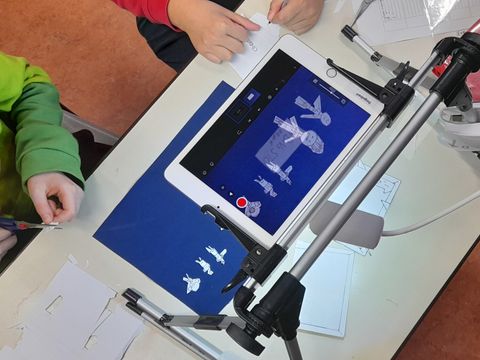 Kinder erstellen Trickfilm mit Legefiguren unter einem Tablet