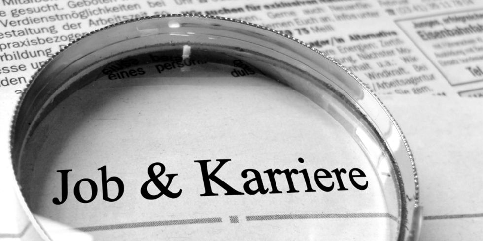 Zeitung mit Lupe über der Überschrift Job und Karriere