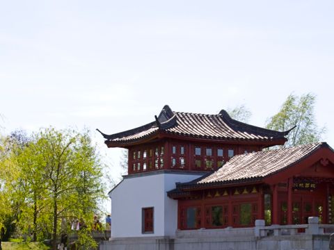 ein Ausschnitt vom Erholungspark Marzahn mit einem See an dessen Ufer ein Gebäude im chinesischen Stil steht