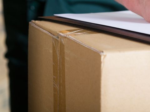 Mann unterschreibt ein Lieferdokument