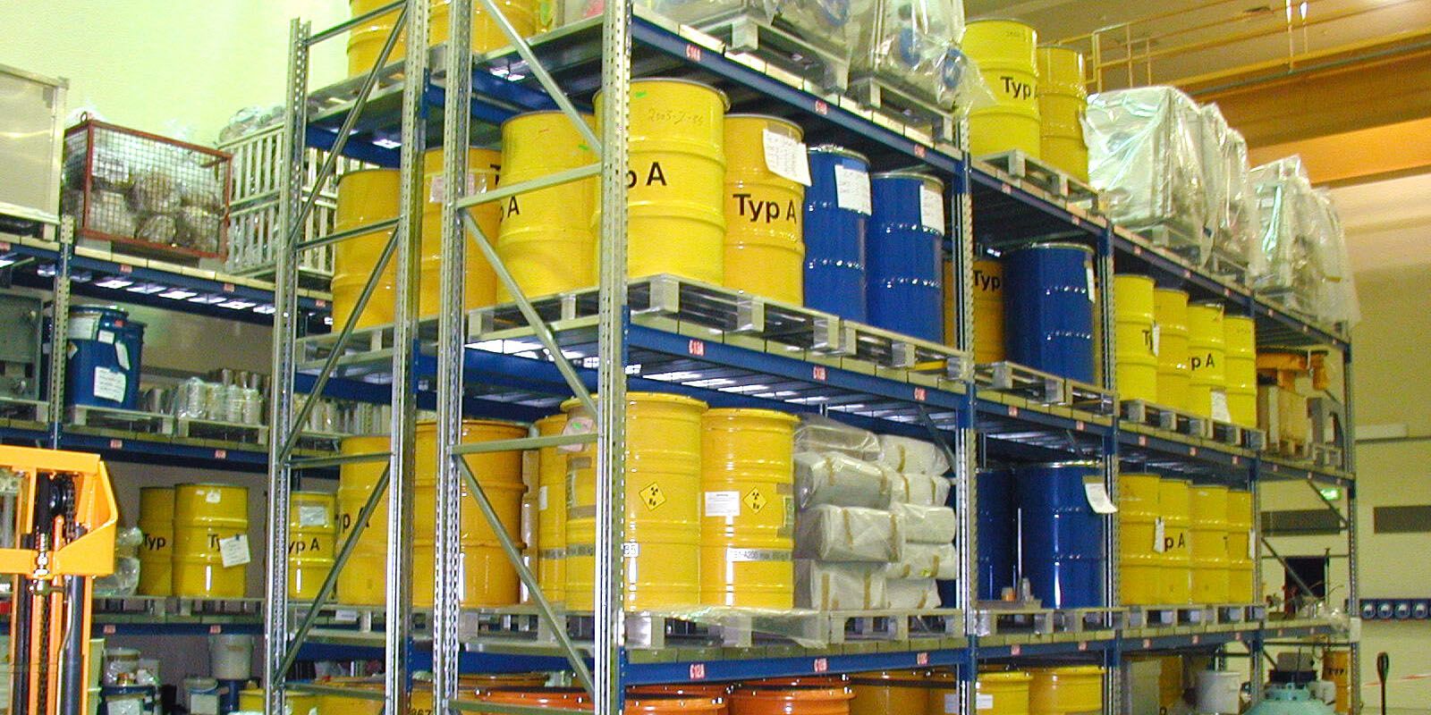 Lagerraum mit farbigen Metallfässer mit Strahlenwarnzeichen in Regalen