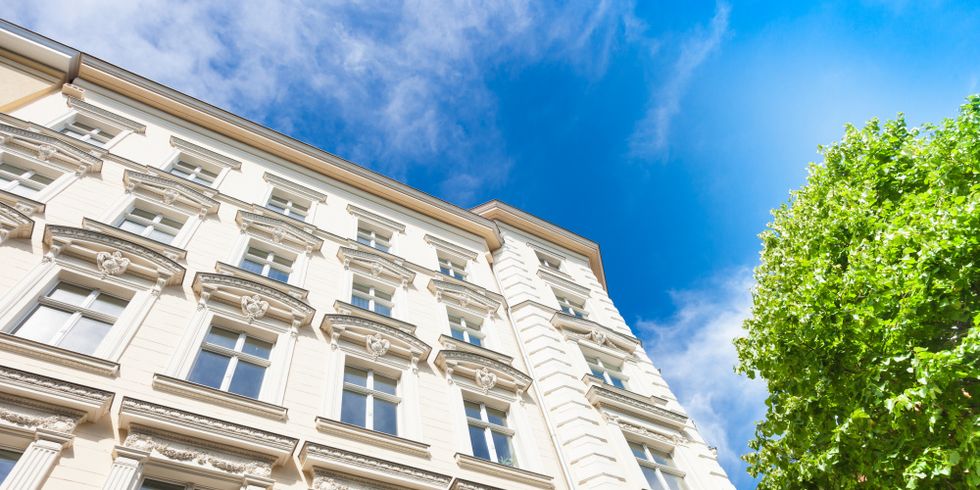 Fassade eines Berliner Altbaus, davor steht ein Baum