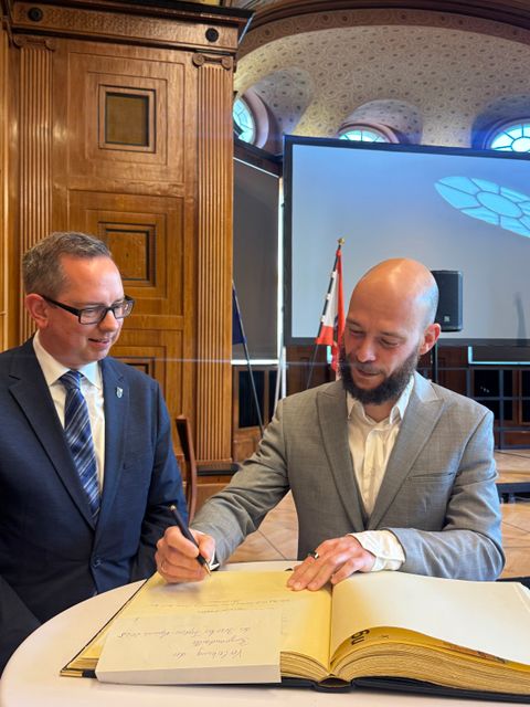 Max Schumann trägt sich ins Goldene Buch ein