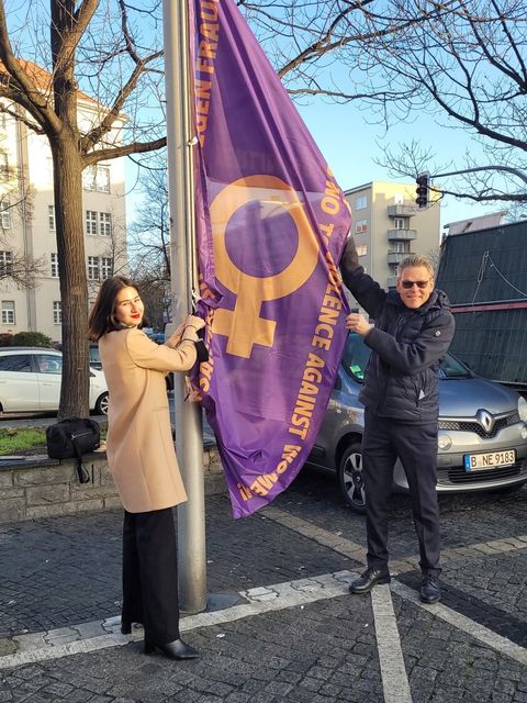 Bezirksbürgermeister Jörn Oltmann (rechts) und Ava A. Moussavi (links) hissen die die landeseigene Antigewaltfahne zum internationalen Tag gegen Gewalt an Frauen und Kindern