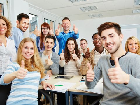 Studenten halten Daumen hoch in der Uni