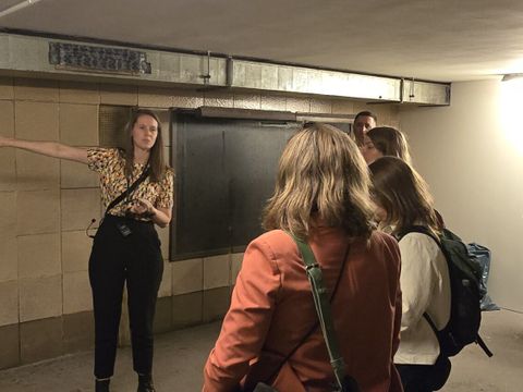 Mitarbeiterin der BVG zeigt Besucher*innen den stillgelegten Zugang des U-Bahnhofes Kottbuser Tor