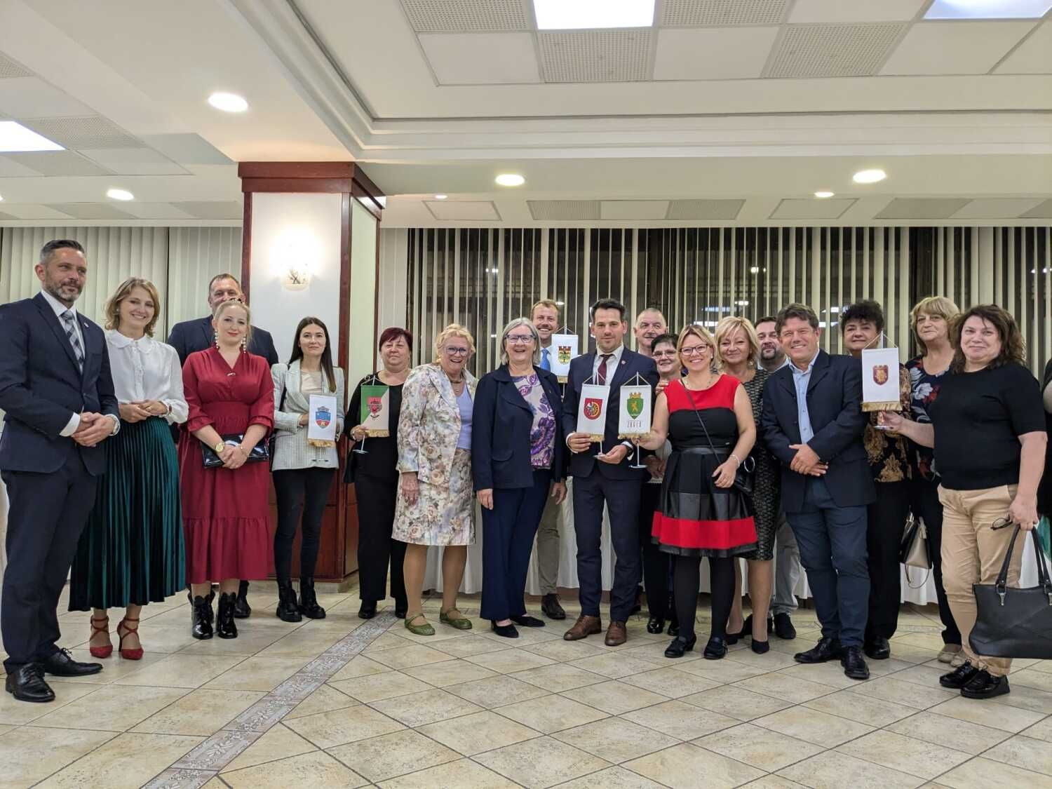 Haben gut lachen: Gruppenbild der Delegationen aus den Partnerstädten, sowie einige Bezirksräte. In der hinteren Reihe Bezirksstadtrat Patrick Steinhoff mit dem Wappen von Steglitz-Zehlendorf