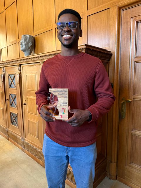 Preisträger Bolu Ajibawo mit Trophäe des Gemeinschaftspreises