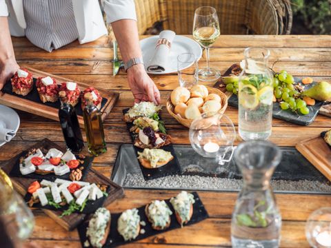 Holztisch ist eingedeckt mit Speisen und Getränken